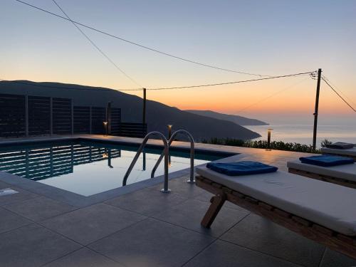 a swimming pool with a view of the ocean at sunset at Villa Athina in Anomeriá