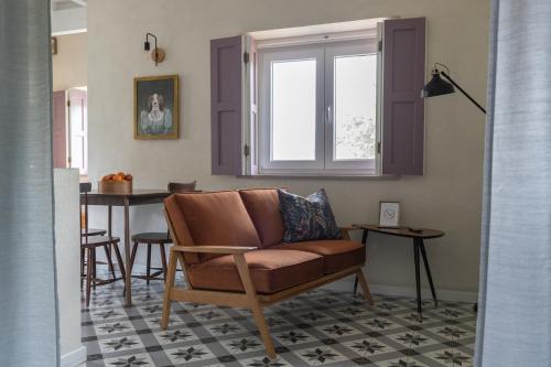 a living room with a chair and a table at Chão do Rio - Turismo de Aldeia in Seia