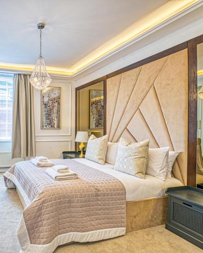 a bedroom with a large bed with a large wooden headboard at Luxury Georgian Townhouse with Cinema and parking in Chester