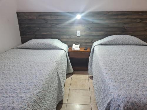 a bedroom with two beds and a wooden wall at Hotel Plaza Colon in Arica