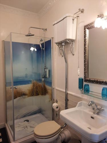 a bathroom with a sink and a toilet and a mirror at Logierhaus am Meer in Wangerooge