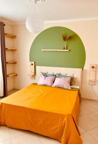 a bedroom with an orange bed with a green wall at Family Tree - WATER Available - SELF check in in Golem