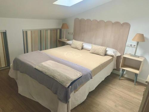 a bedroom with a large bed with a large headboard at Precioso apartamento castro Urdiales in Castro-Urdiales