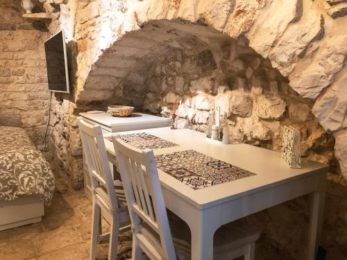 eine Küche mit einem Tisch und Stühlen in einer Steinmauer in der Unterkunft Tao Stones - Alloggio in pietra in Conversano