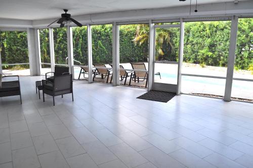 a living room with a white tile floor and windows at Bike to the beach, walk to restaurants, heated pool, secluded in Fort Lauderdale