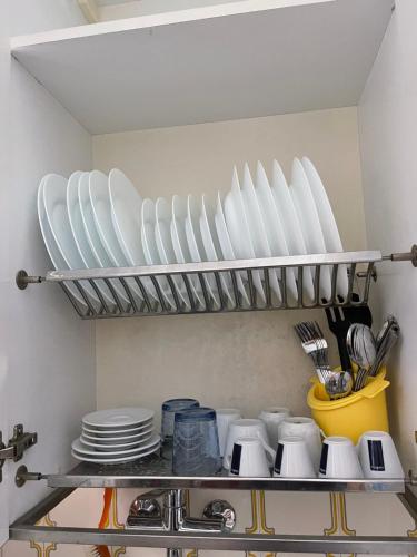 a shelf with plates and utensils in a kitchen at da Lilia in Salute&Bellezza in Monfalcone