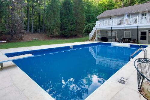 a swimming pool with blue water in front of a house at Immaculate Suwanee House with Pool and Game Room! in Suwanee