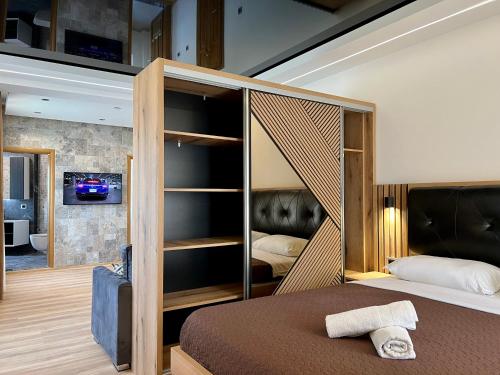 1 dormitorio con 1 cama con cabecero de madera en Blue Star Apartments, en Ulcinj