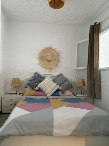 a bedroom with a bed with a colorful blanket and two lamps at Cabo Negro Appart M&M in Cabo Negro