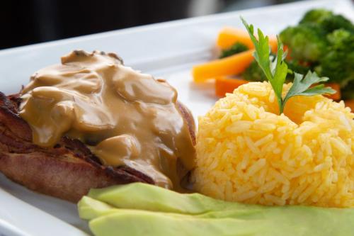a plate of food with meat and rice and vegetables at Hotel La Cascada - Lago Agrio in Nueva Loja
