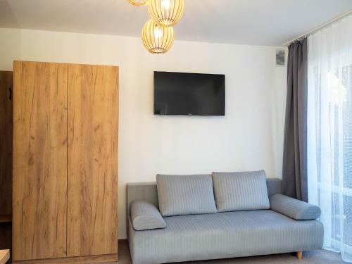 a living room with a couch and a flat screen tv at Osada turystyczna Malinów in Szczawnica