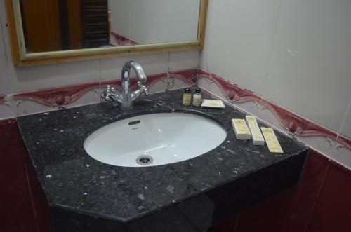 a bathroom sink with a black counter top at Park Hotel Gilgit in Gilgit