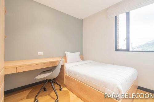 a small bedroom with a desk and a bed at CentralX 21 Bogotá in Bogotá