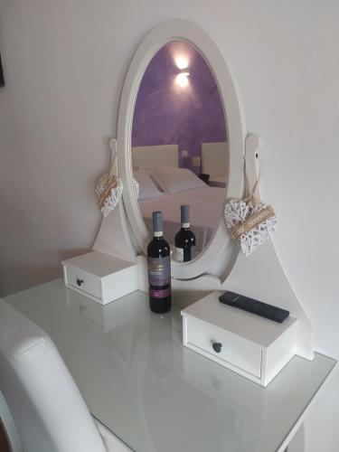 un espejo y dos botellas de vino en una mesa en B&B Villa la Bouganville en Camaiore