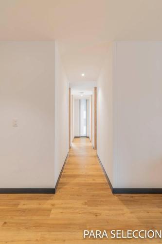 an empty hallway with white walls and wood floors at CentralX 21 Bogotá in Bogotá