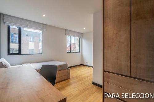 a bedroom with a bed and a table in a room at CentralX 21 Bogotá in Bogotá