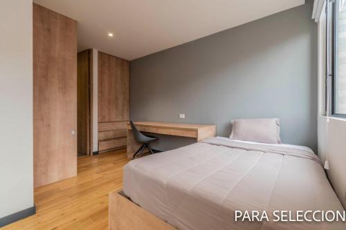 a bedroom with a bed and a desk at CentralX 21 Bogotá in Bogotá