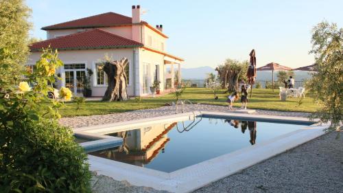 a house with a swimming pool in front of a house at Agroturizem Bylis in Hekal