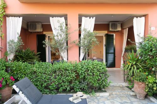 a pink house with a bench and some plants at Penelope Corfu Suite in Corfu Town