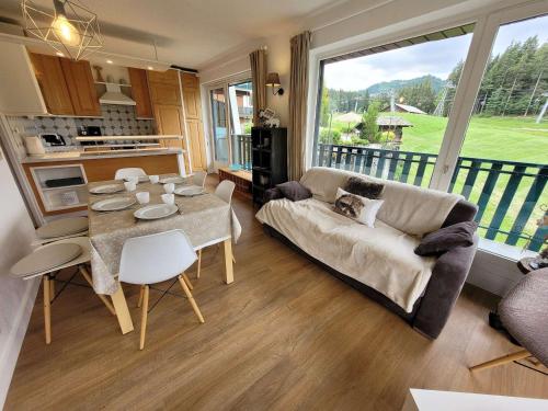 un salon avec un canapé et une table dans l'établissement Appartement skis aux pieds avec piscine, rénové et confortable - FR-1-598-18, aux Gets
