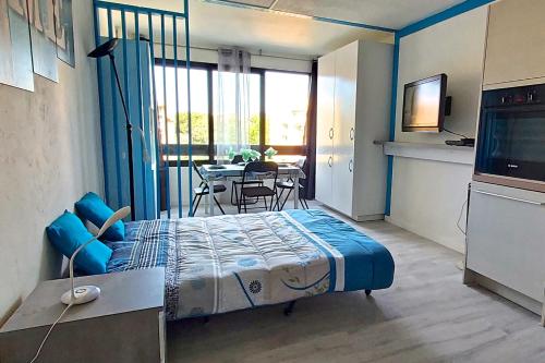 une chambre avec un lit, une table et une télévision dans l'établissement HYPERCENTRE 27 m avec WIFI et PISCINE partagée, à Fréjus
