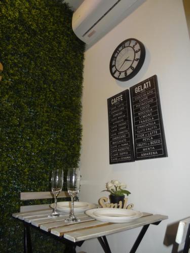 a table with two glasses and a clock on the wall at Cozy Rooms - BAÑERA HIDROMASAJE in Valencia