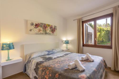 1 dormitorio con 1 cama con 2 toallas en Villa Julieta 454, en Crestatx