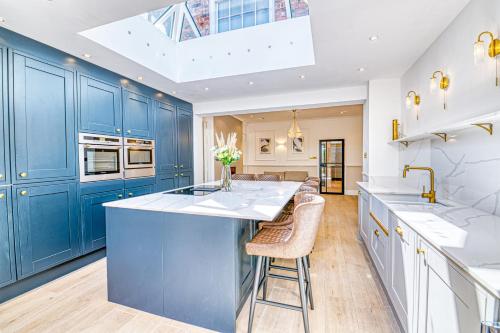a kitchen with blue cabinets and white counter tops at Luxury Georgian Townhouse with Cinema and parking in Chester