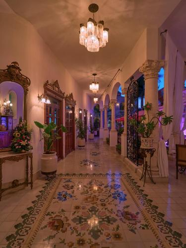 a lobby of a hotel with potted plants and a chandelier at El Palacito Secreto Luxury Boutique Hotel & Spa in Mérida