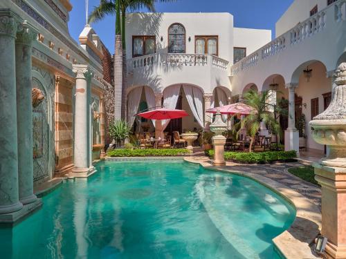 a pool in the courtyard of a house with umbrellas at El Palacito Secreto Luxury Boutique Hotel & Spa in Mérida