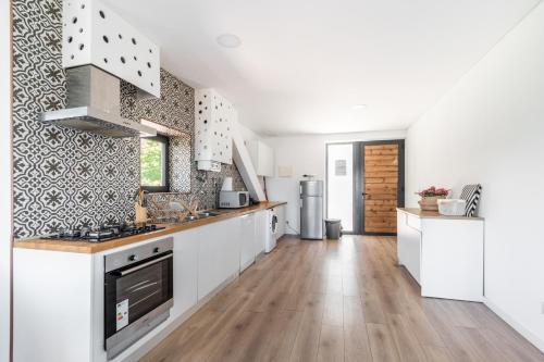 a kitchen with white cabinets and a wooden floor at Apartamentos Do Ermal in Vila Boa