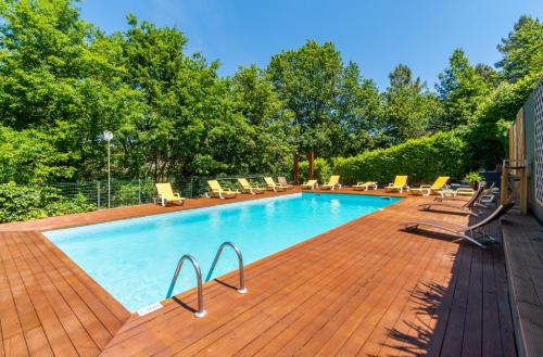 a swimming pool with lounge chairs on a wooden deck at Apartamentos Do Ermal in Vila Boa