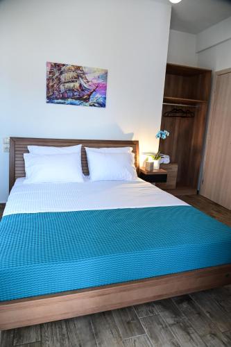 a bedroom with a large bed with a blue blanket at BIG BLUE HOTEL in Amaliápoli