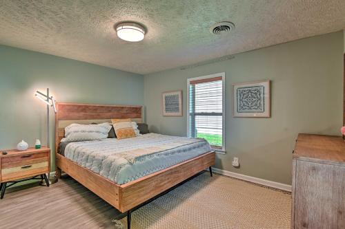 a bedroom with a large bed and a window at Quaint Downtown Murfreesboro Cottage with Lush Yard in Murfreesboro