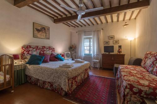 sypialnia z łóżkiem i kanapą w obiekcie B&B Arivellini w mieście Vicopisano