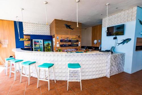 eine Bar mit Hockern vor einer Theke in der Unterkunft Flat Ponta Negra Beach - Ap 401 in Natal