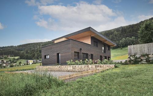 a wooden house in the middle of a field at Black Forest Lodges - gehobene Ferienwohnungen mit Privatsaunas in Tulfes