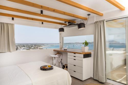 Un dormitorio con una cama y una ventana grande. en 37 2 Heaven, en Naxos Chora
