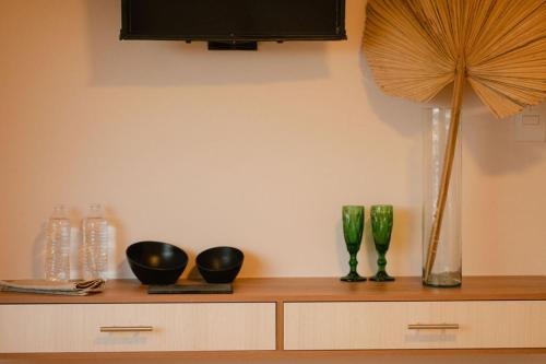 a wooden cabinet with vases and a fan on it at Hotel Fratelli in Aguascalientes