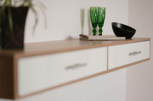 a dresser with two green vases on top of it at Hotel Fratelli in Aguascalientes