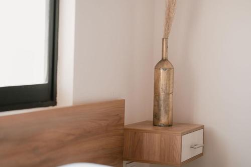 a vase sitting on a wooden stand in a room at Hotel Fratelli in Aguascalientes