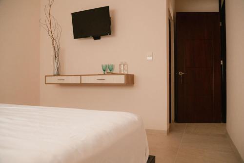 a bedroom with a bed and a tv on the wall at Hotel Fratelli in Aguascalientes