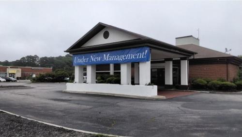 a building with a blue sign in a parking lot at Onley Inn in Onley
