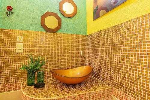 a bathroom with a wooden tub on a tiled wall at Chalés Ilhabela in Ilhabela