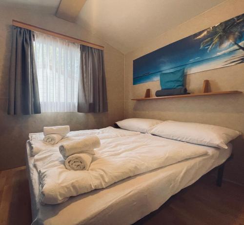 1 dormitorio con 2 camas y toallas. en Dalmacia mobile homes and caravans at the beach, en Privlaka