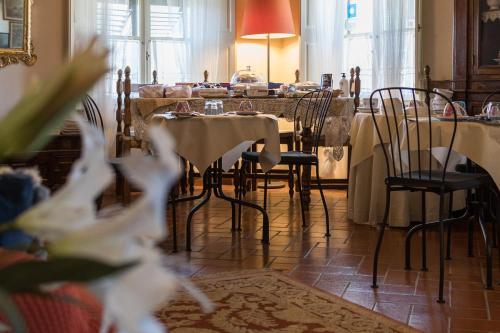 jadalnia ze stołami i krzesłami oraz pokój z stolikiem w obiekcie B&B Arivellini w mieście Vicopisano