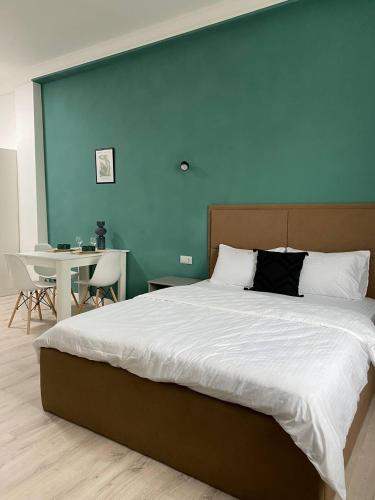 a bedroom with a large bed with a blue wall at Жилой Комплекс Акжайык in Astana