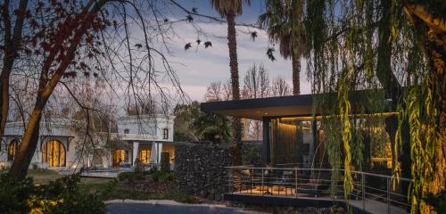 a house with a glass facade and trees at Susana Balbo Winemaker´s House in Ciudad Lujan de Cuyo