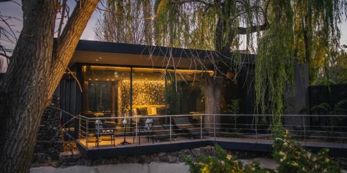 a house in the woods with a tree at Susana Balbo Winemaker´s House in Ciudad Lujan de Cuyo