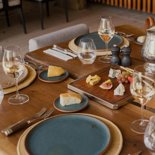 a wooden table with plates of food and glasses of wine at Susana Balbo Winemaker´s House in Ciudad Lujan de Cuyo